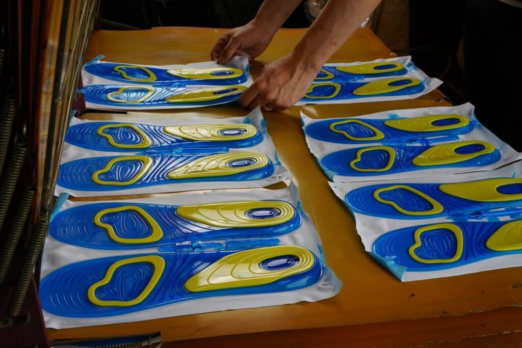 Multilayer insole manufacturing process with layered materials and cushioning components