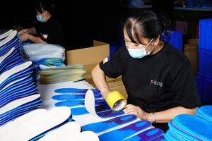 Workers performing quality inspection on shoe insoles during the manufacturing process