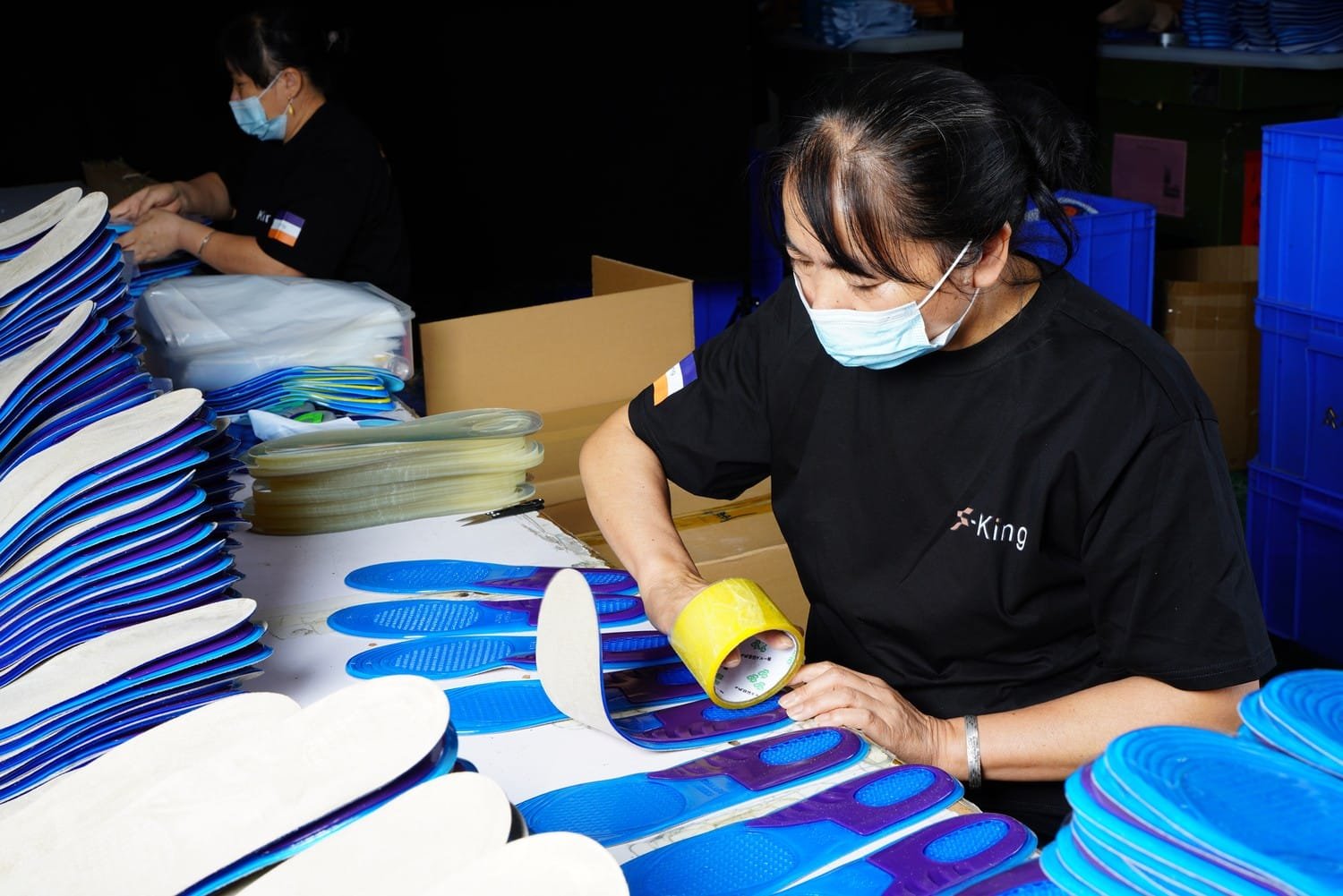 Workers performing quality inspection on shoe insoles during the manufacturing process